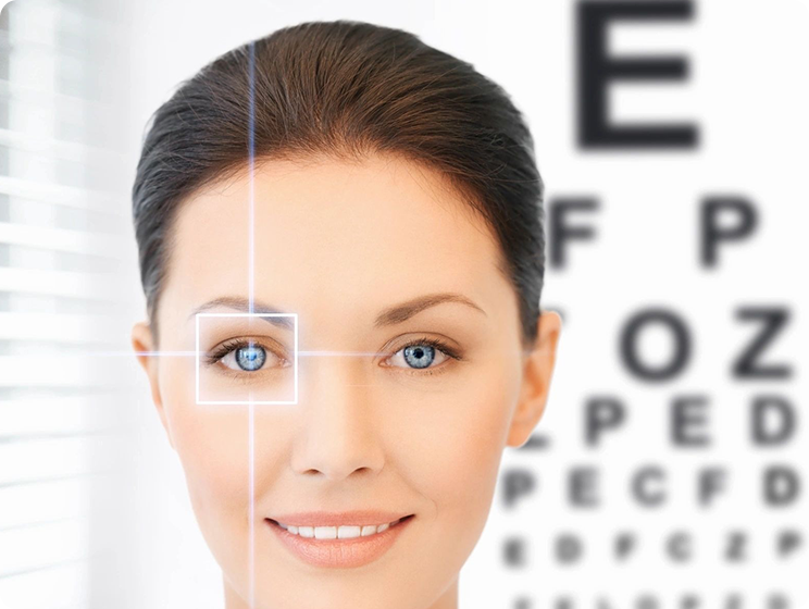 A woman with blue eyes and an eye chart in the background.