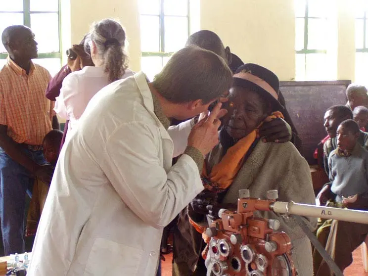 Dr. Rousselo volunteering in kenya doing eye check for a lady