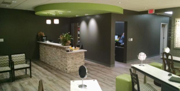 A reception area with a green wall and stone counter.